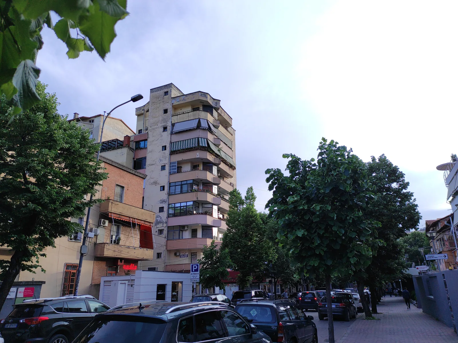 Tree-lined street and apartment buildings in Blloku, Tirana, photographed in 2021